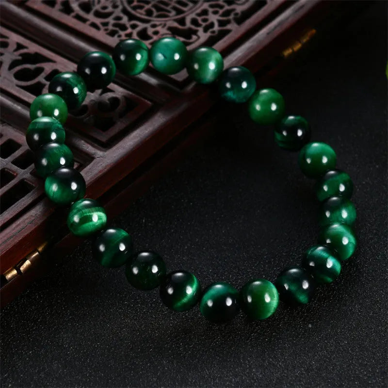 Natural green tiger eye stone bracelet with geometric polished beads on a wrist.