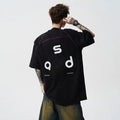 Loose-fit black cotton short-sleeve t-shirt with white letter print graphic on a mannequin.