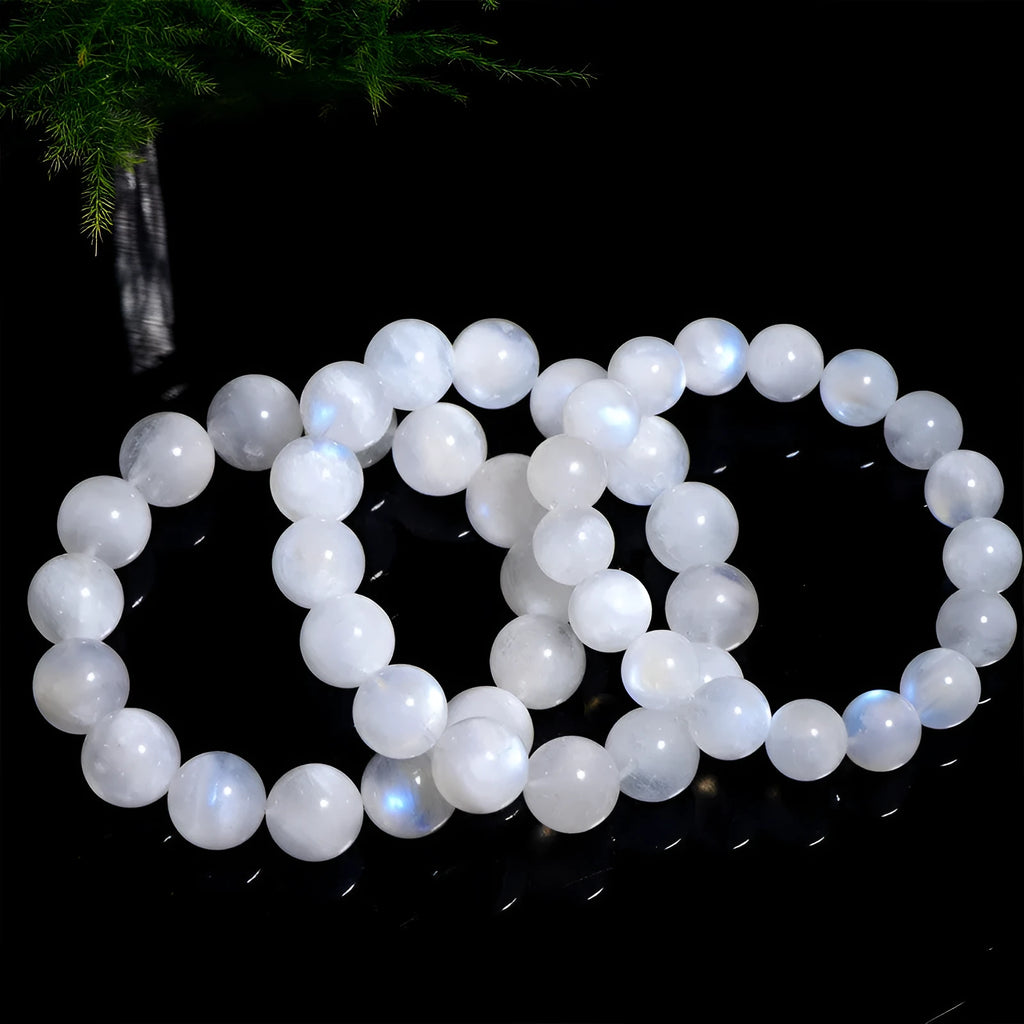 Natural blue polished moonstone round bead bracelet with adjustable clasp on a wrist.
