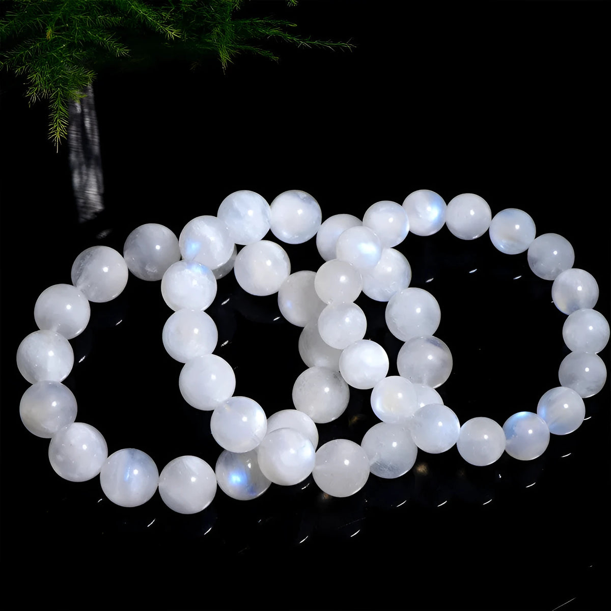 Natural blue polished moonstone round bead bracelet with adjustable clasp on a wrist.