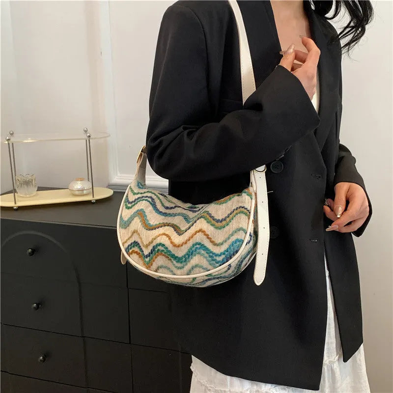 Women's knitted straw woven crossbody bag showing woven texture and internal phone/document compartments