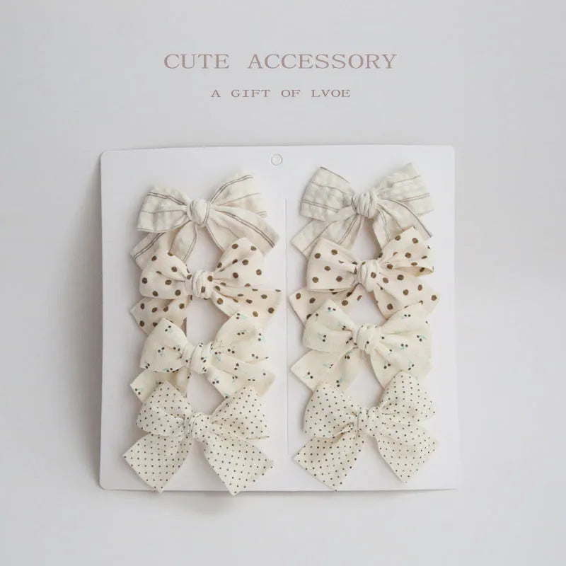 Set of children's cloth hair clips with a dovetail bow design in various colours.