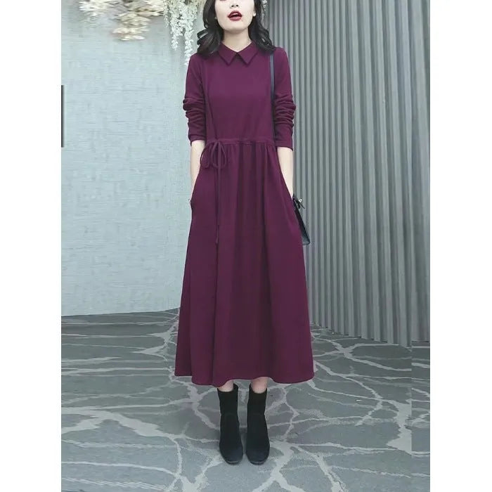 Purplish red plus size long sleeve long skirt dress for women on a hanger.