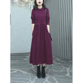 Purplish red plus size long sleeve long skirt dress for women on a hanger.