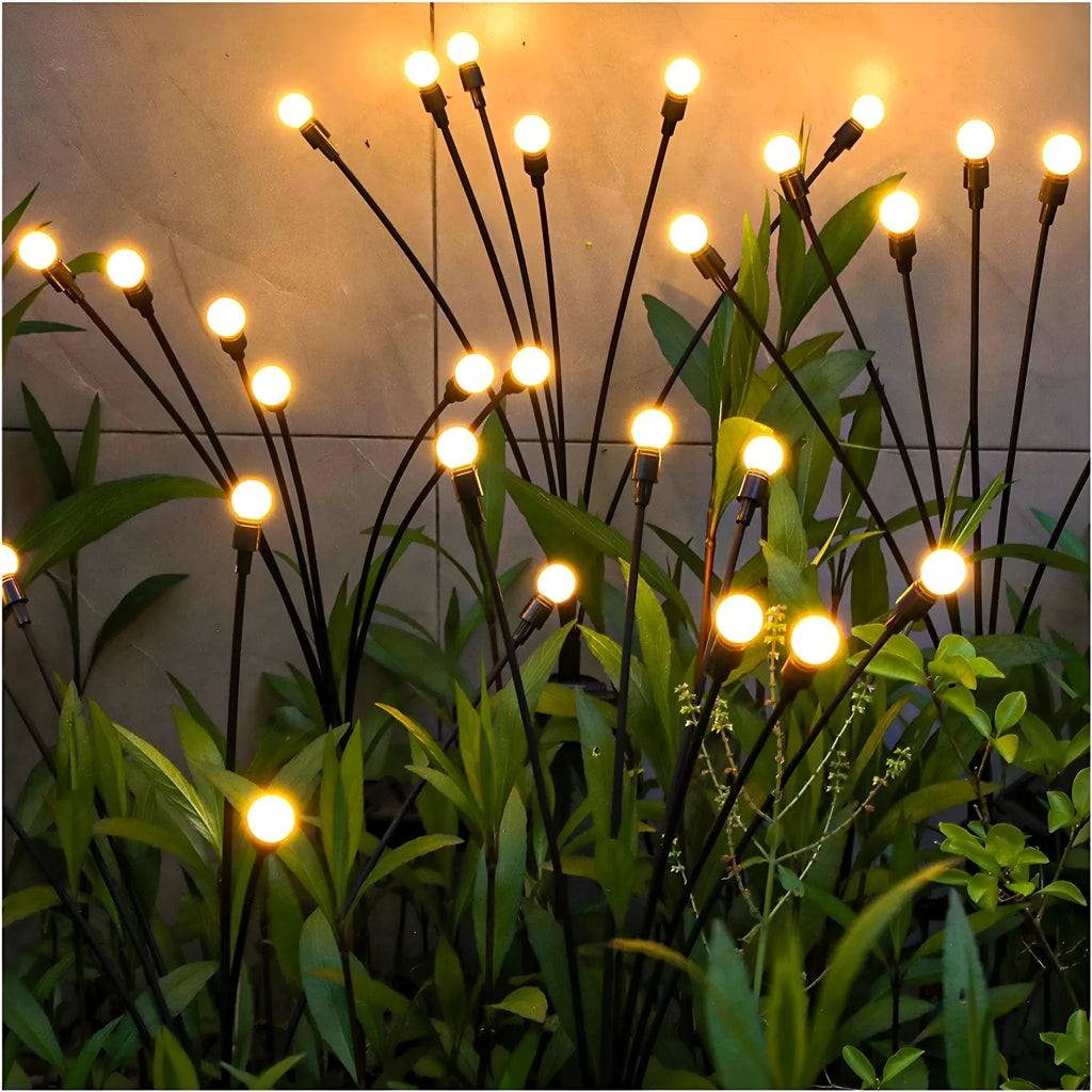 Solar-powered LED garden light with multiple heads on a metal spike in grass.