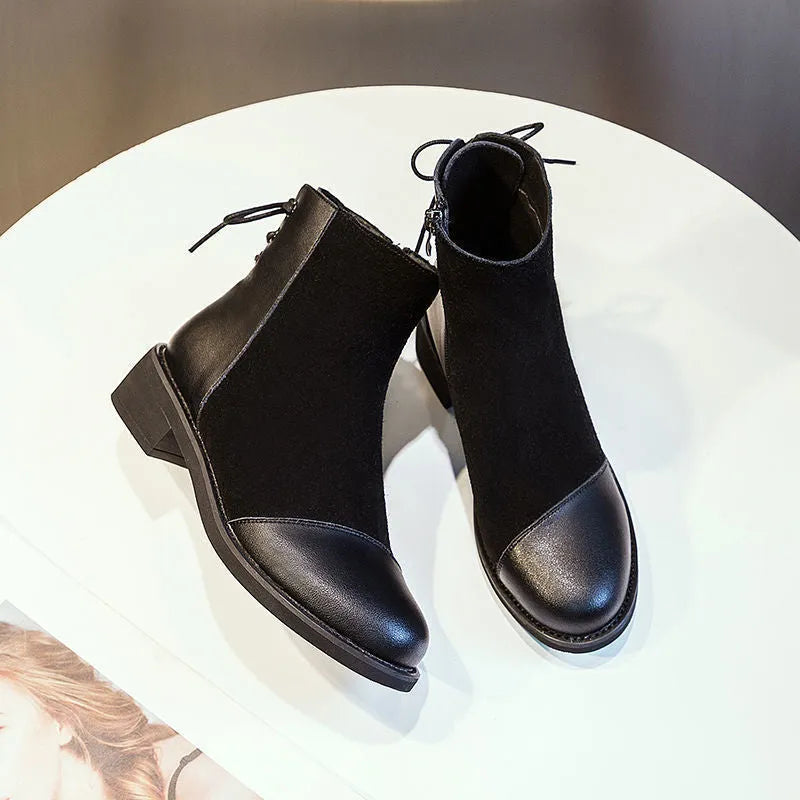 Black women's knee boots with side zip, round toe, short heel and decorative bow.