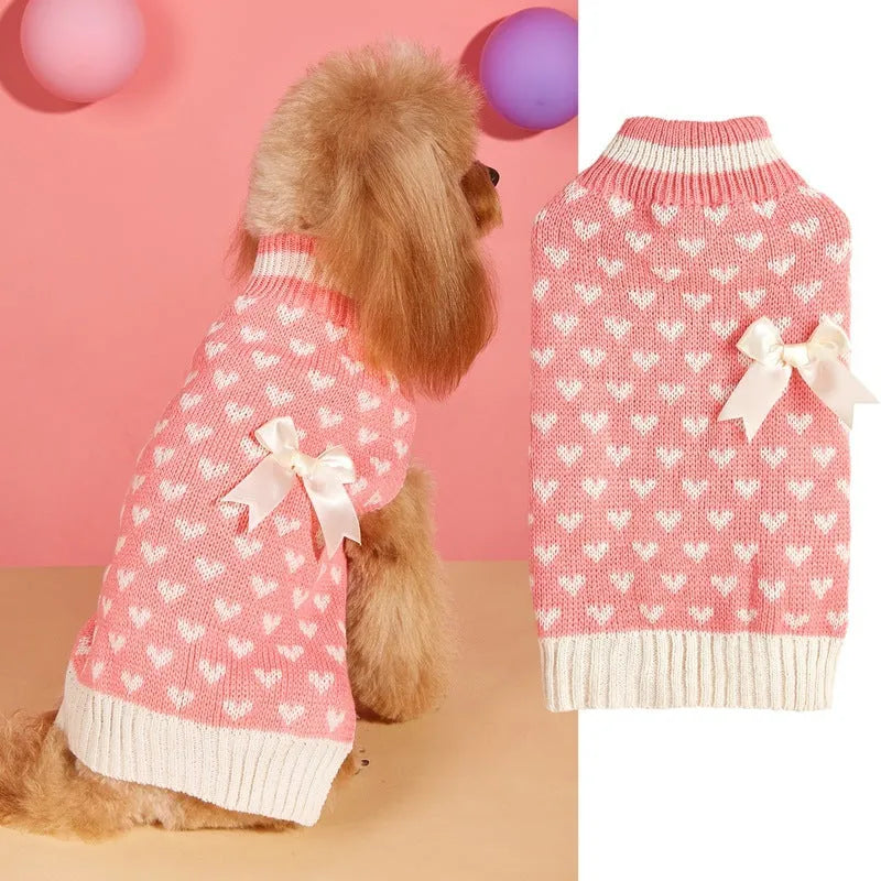 Red dog sweater with a white love heart and bow decoration on a small dog.