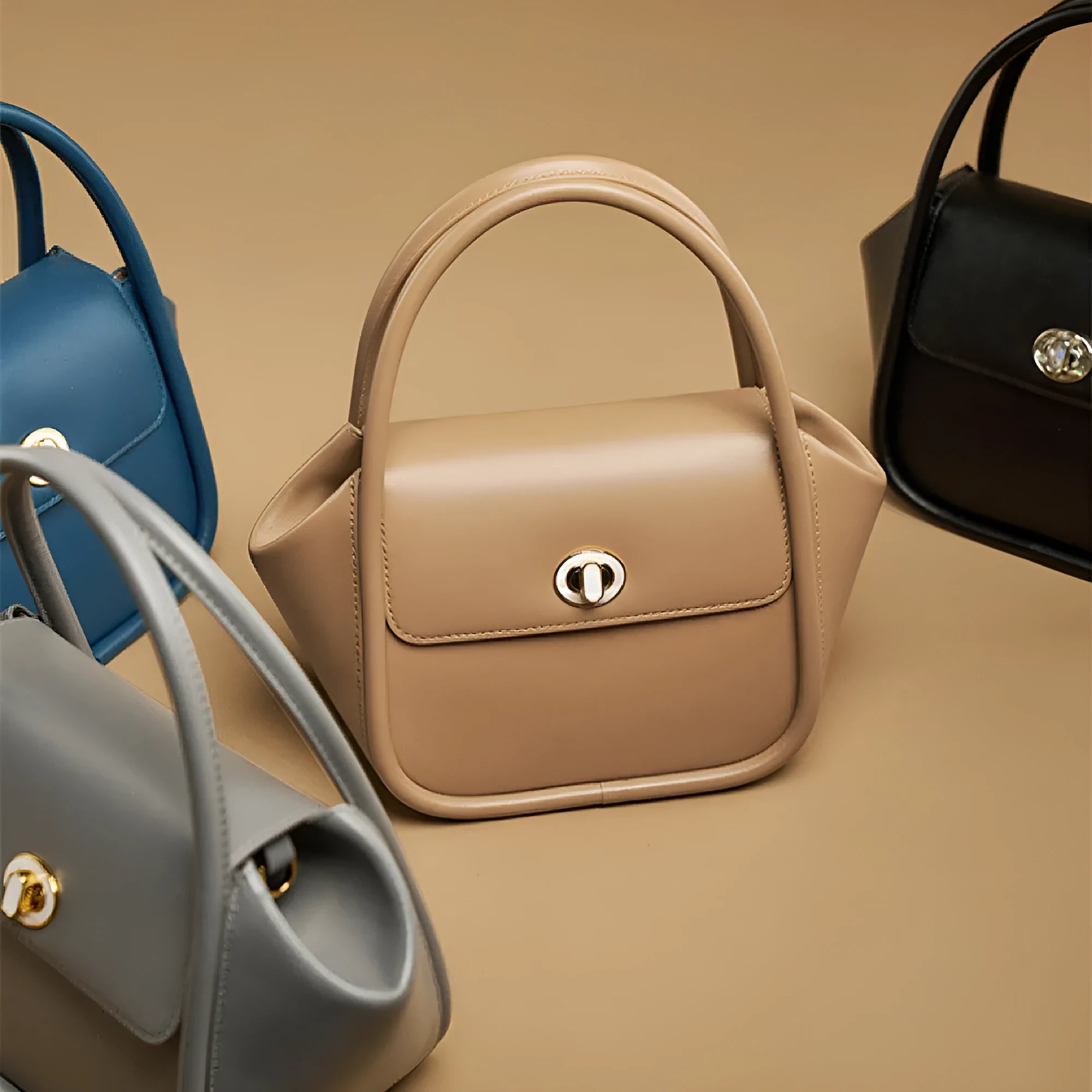 A wing-shaped women's leather tote bag with a buckle latch, shown in blue with a cross-body strap.