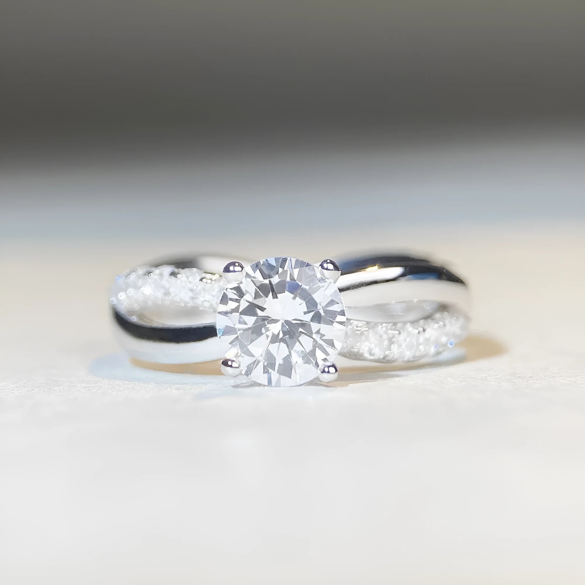 Women's geometric cross moissanite ring with twisted silver band and 1 carat stone.
