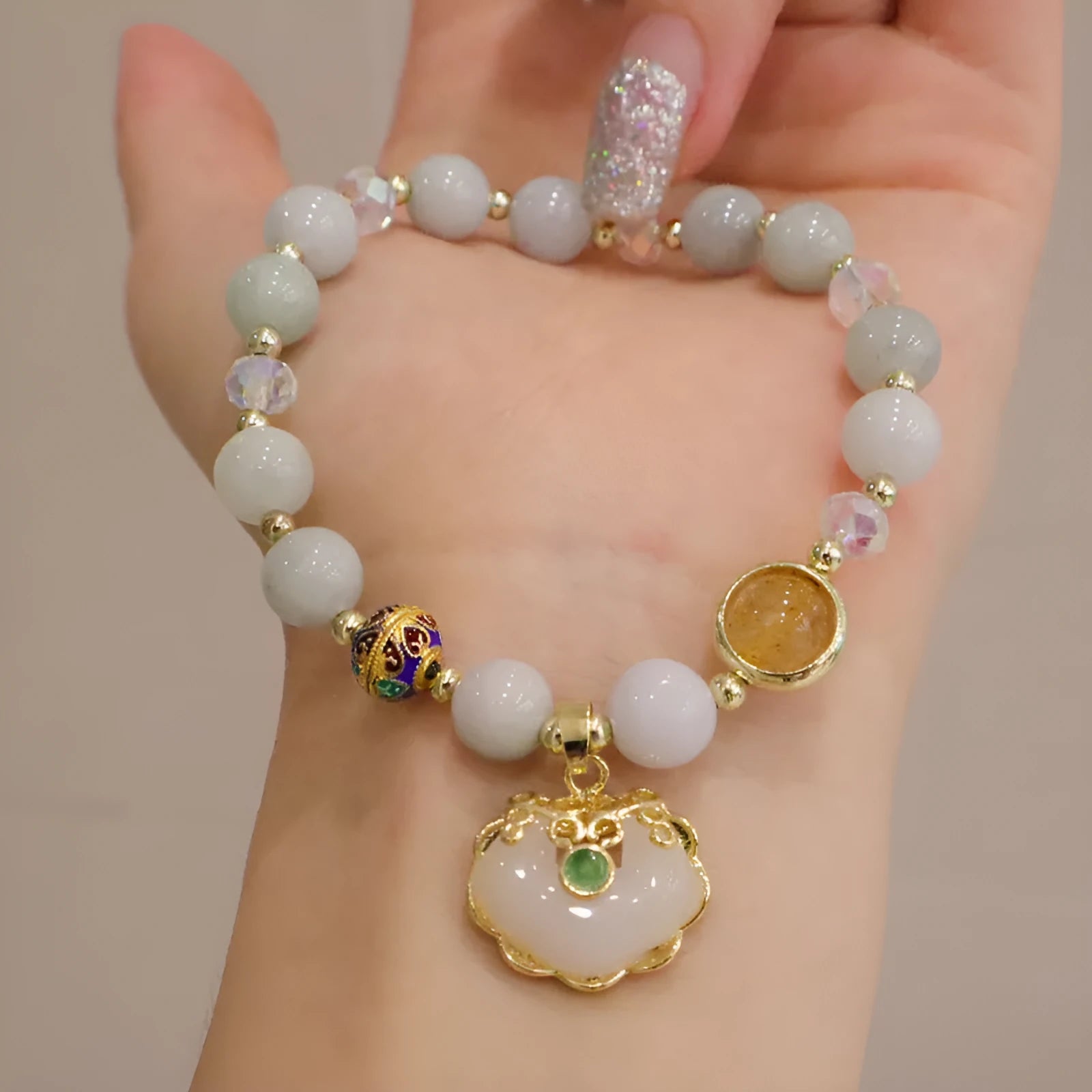 Women's ethnic bracelet with geometric metal decorations and strawberry quartz or gray jade beads