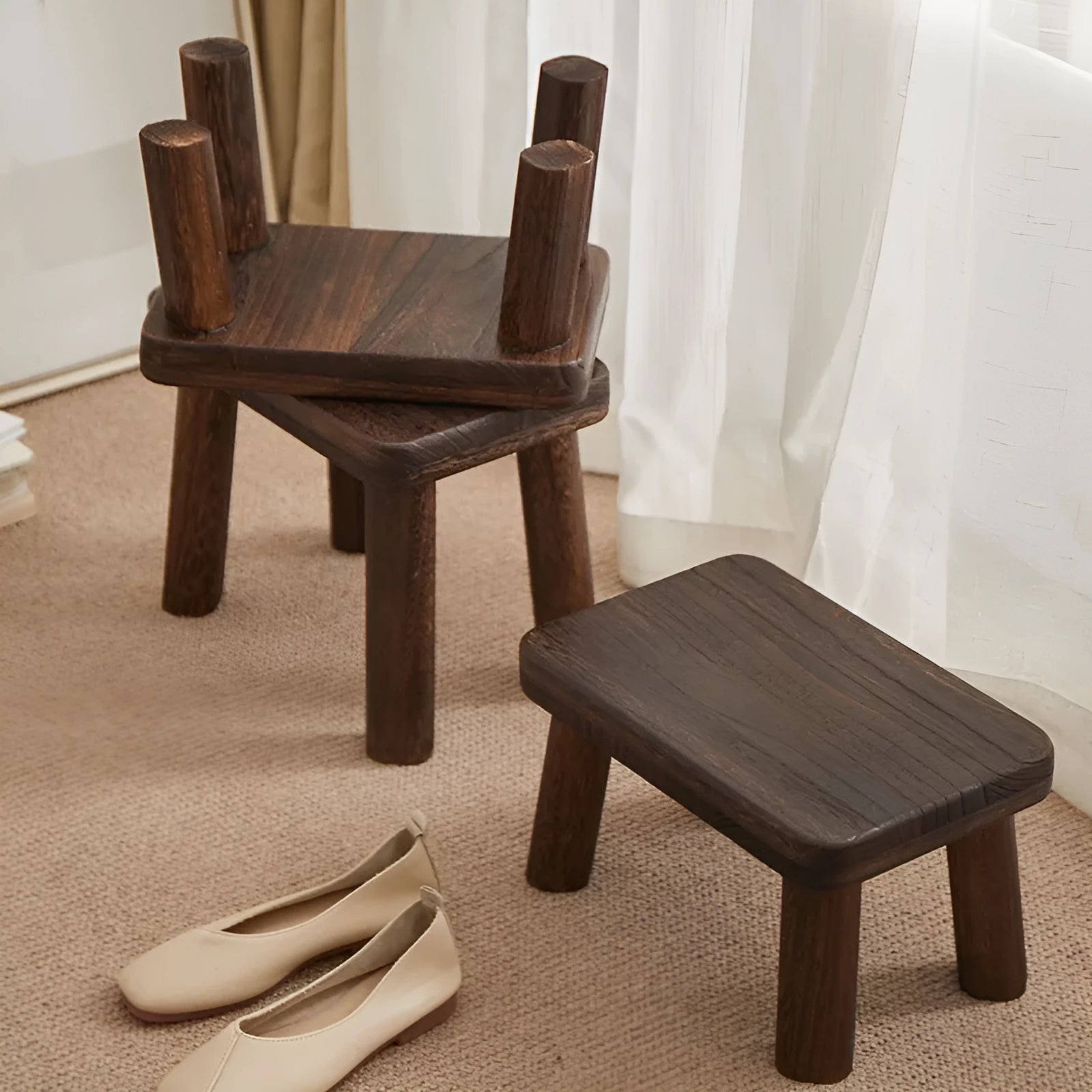 Solid wood changing stool with distressed finish and bracket legs in a living room setting.