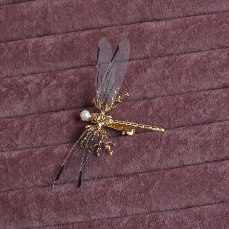 Gold-coloured dragonfly headdress with side clip fastening and floral decorative elements
