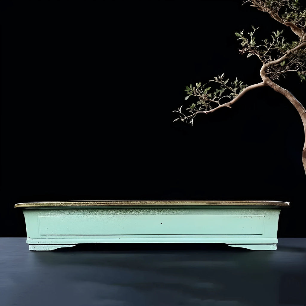 Green handmade ceramic bonsai pot with purple sand crackled glaze on wooden surface