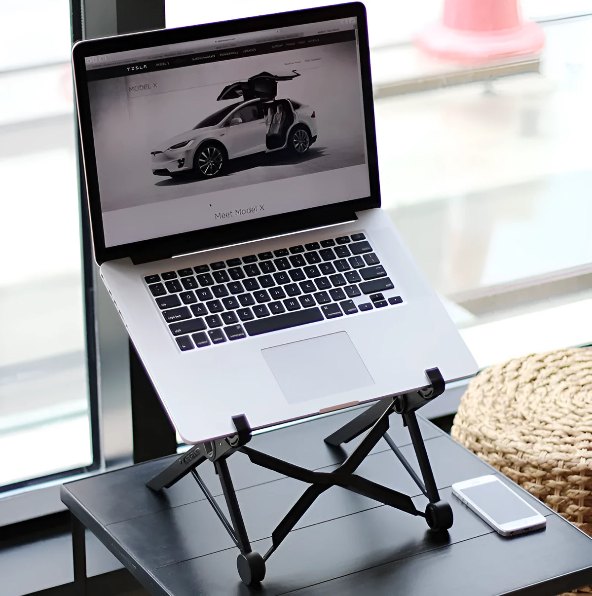 Black folding laptop stand with reinforced nylon construction showing compact folded position