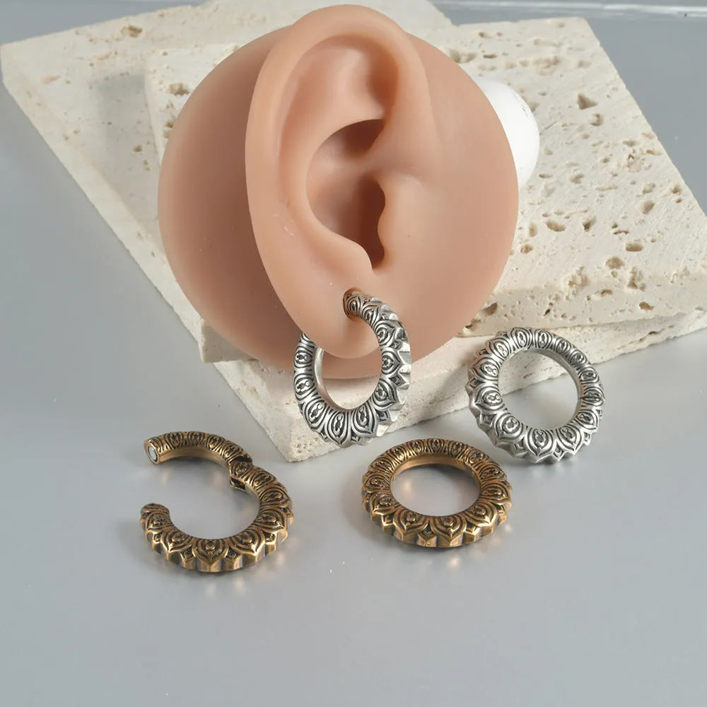 Close-up of large geometric dragon silhouette hollow out alloy earrings in antique silver finish.