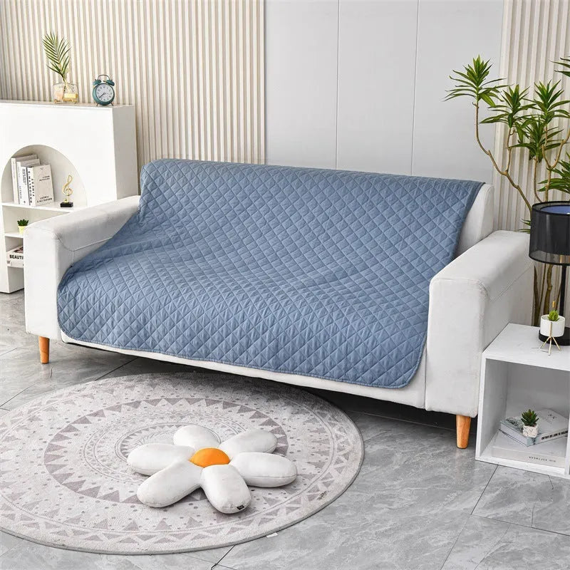 Waterproof reversible dog blanket on sofa showing two colour sides, protecting furniture from pet stains and hair