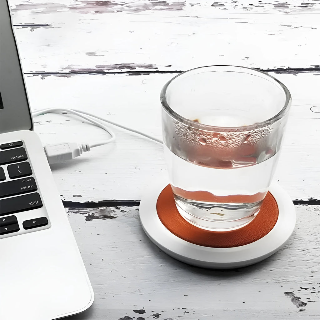 USB-powered insulated heating coaster in black, blue, or orange on a desk.