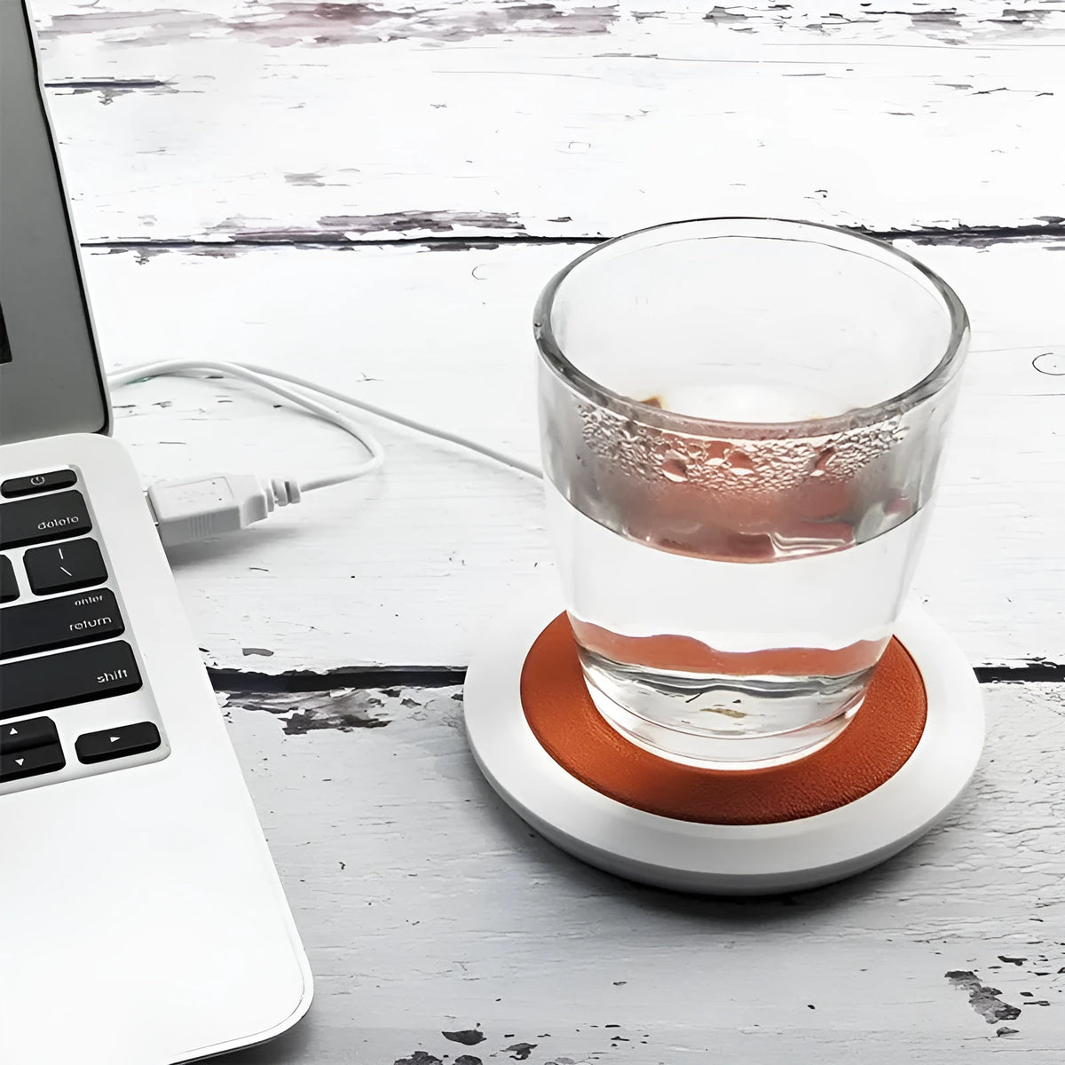 USB-powered insulated heating coaster in black, blue, or orange on a desk.