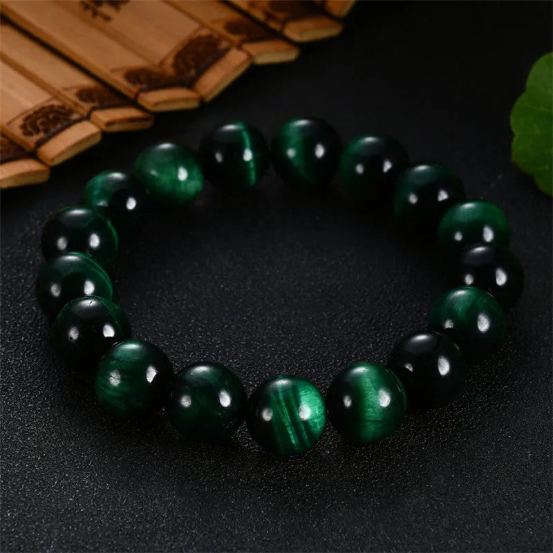 Natural green tiger eye stone bracelet with geometric polished beads on a wrist.