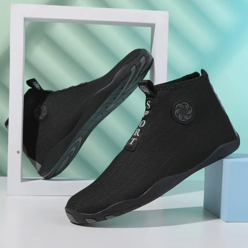 Men's black and fluorescent green quick-dry mesh beach shoes with a non-slip rubber sole on a rocky surface.