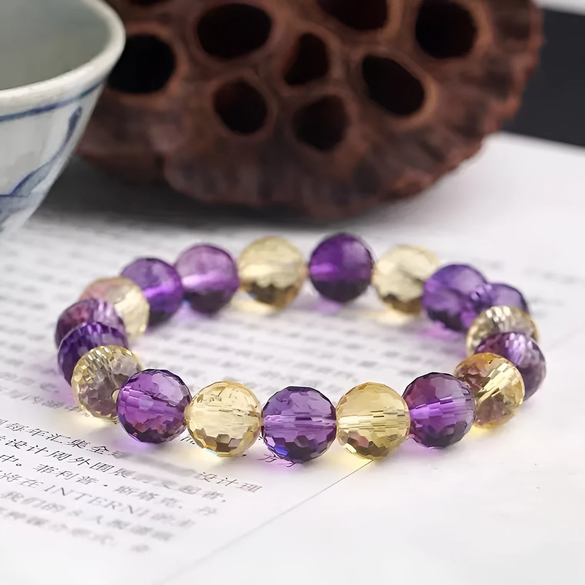 Hand-crafted ametrine bracelet with 128-facet cut crystal beads on a wrist.