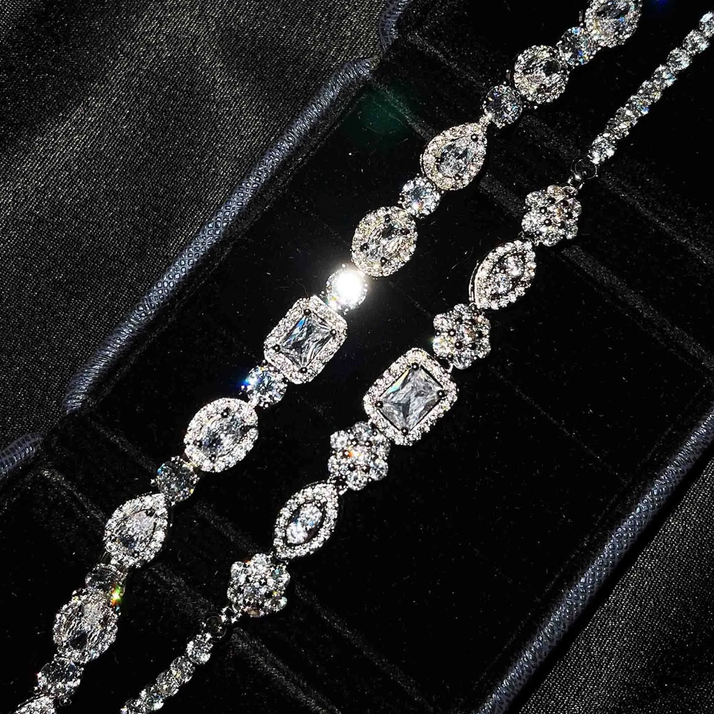 Women's geometric silver and white gold plated bracelet with inlaid zircon stones on a model's wrist.