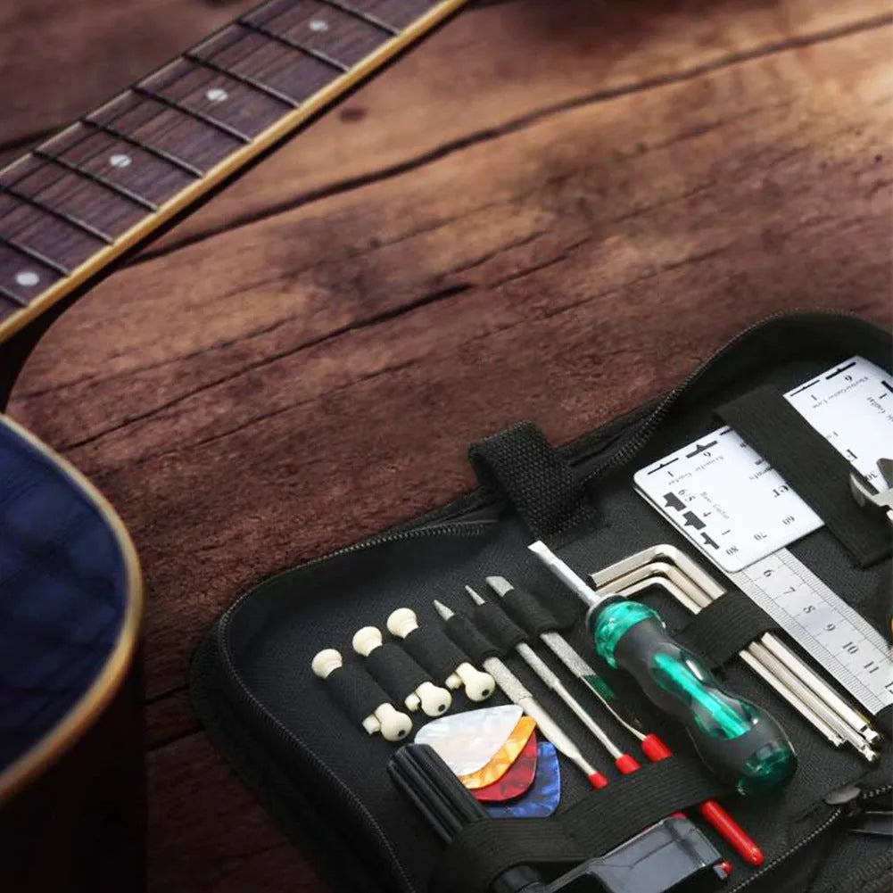 Black guitar repair and care tool kit with plastic and metal tools for instrument maintenance.