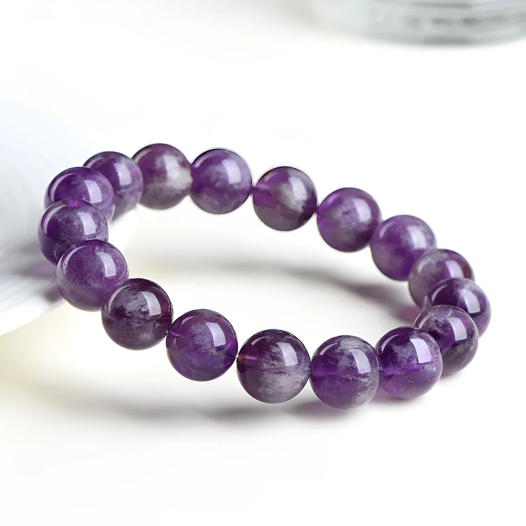 Natural feather amethyst crystal bracelet with geometric scattered beads and Ruyi design on a wrist.