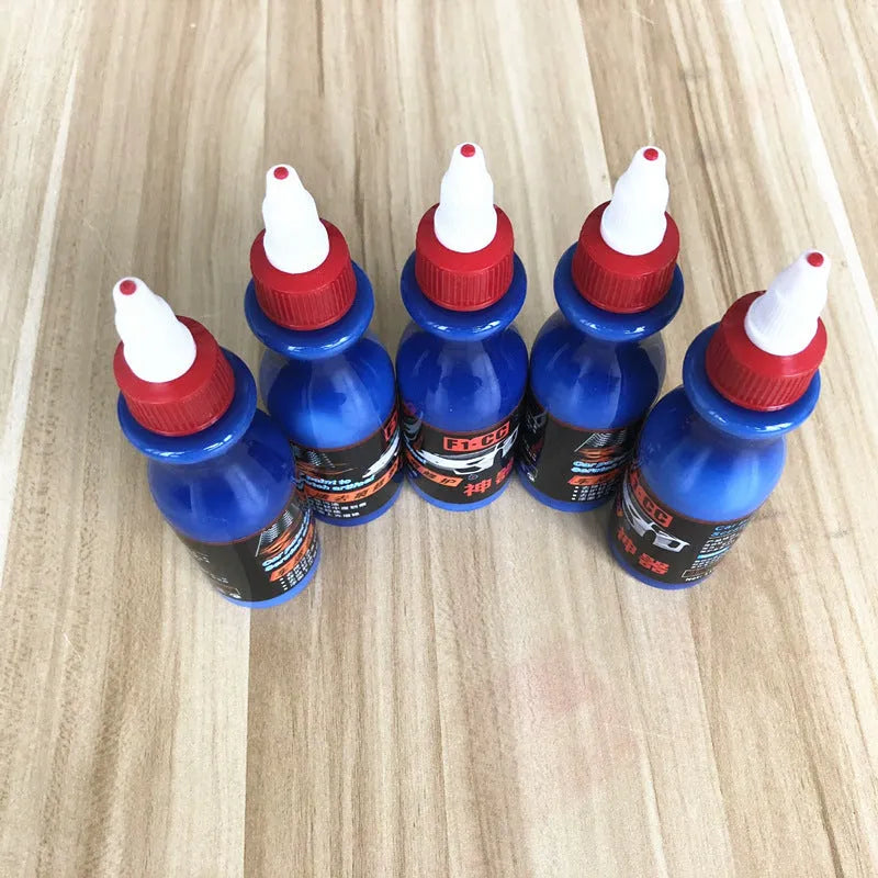 Blue car scratch repair kit with bottle of repair agent and application tool for automotive paint touch-ups