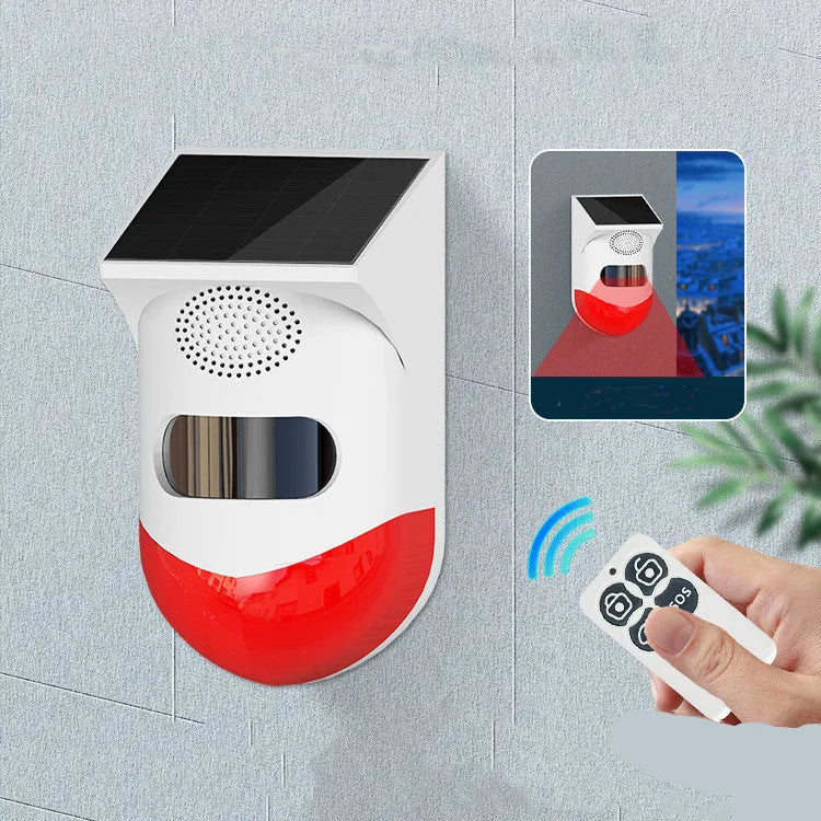 Solar panel human body infrared sensing security alarm with remote control on a wall.