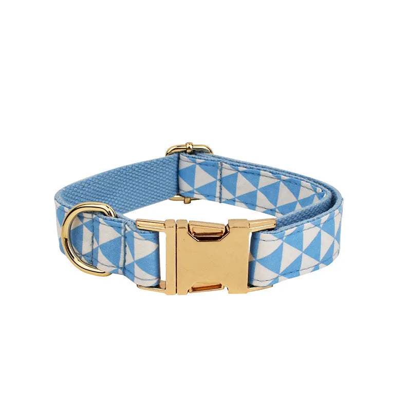 Blue cloth dog collar, leash, vest, and bow set arranged together showing all four pieces.