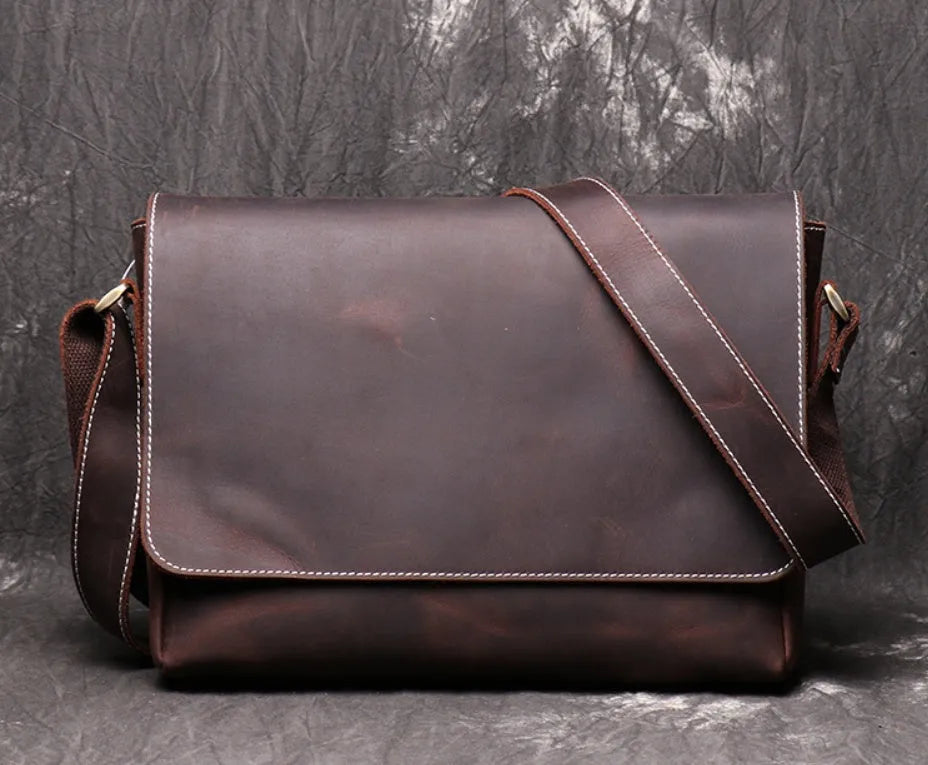 Vintage brown leather mens messenger bag with a flap opening and adjustable shoulder strap.