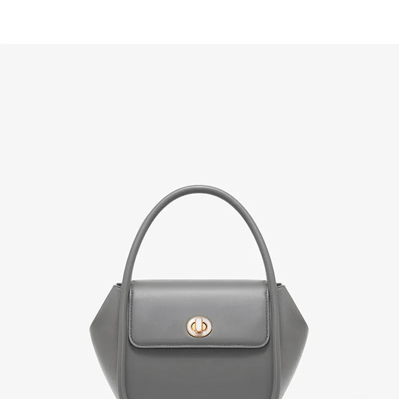 A wing-shaped women's leather tote bag with a buckle latch, shown in blue with a cross-body strap.