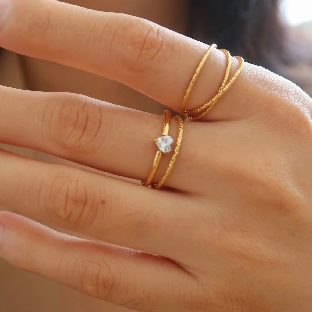 Golden stainless steel ring with love heart and oval designs showing electroplated finish and simple bracelet style