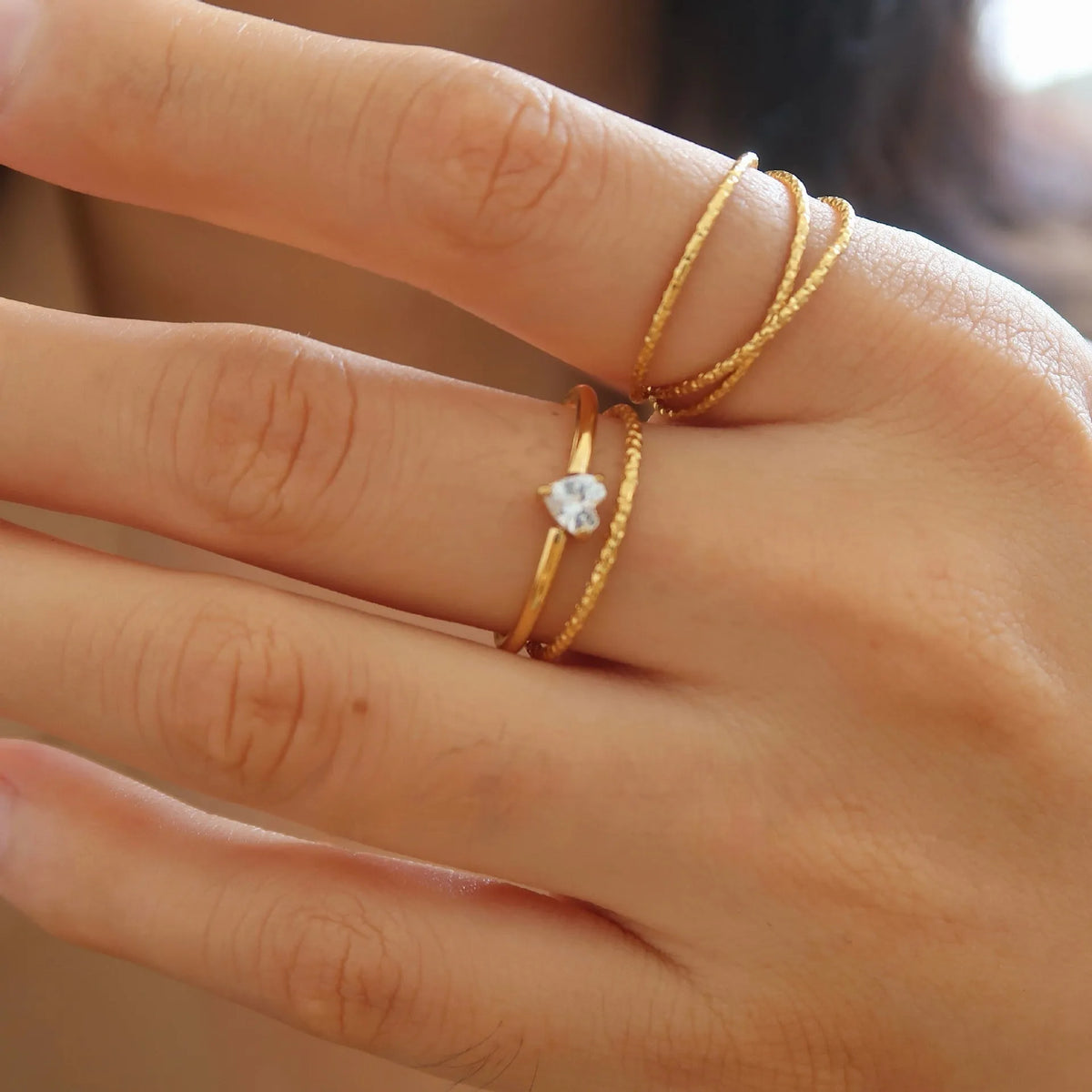 Golden stainless steel ring with love heart and oval designs showing electroplated finish and simple bracelet style