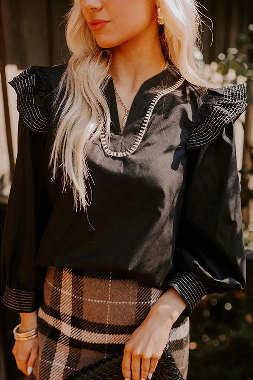 Black women's blouse with V-neckline and long ruffle sleeves
