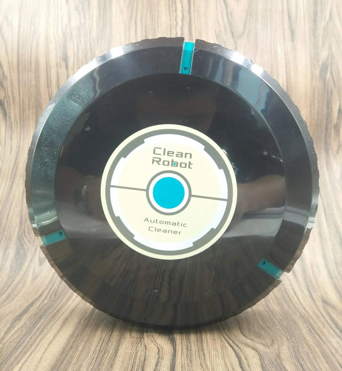 Black and white AC automatic sweeping robot cleaner on a hardwood floor.