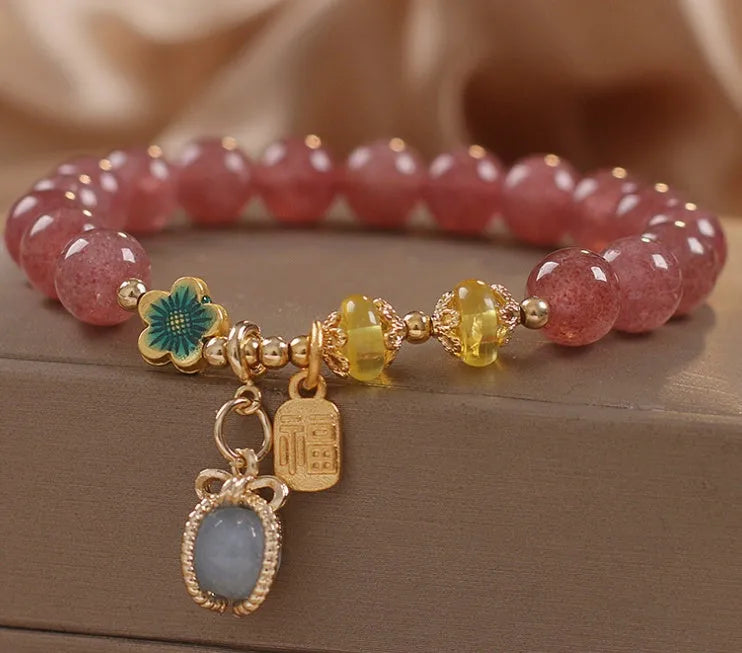 Red women's bracelet with strawberry quartz beads, alloy metal elements, and rhinestone decorative details on adjustable band