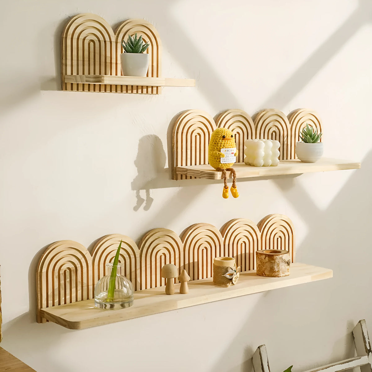 Solid wood multi-layer wall-mounted shelf holding several small potted plants.