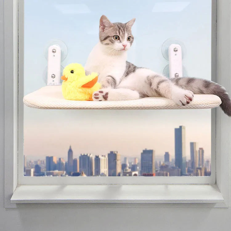 Stainless steel frame cat hammock with suction cups attached to a window, shown in beige mesh fabric.