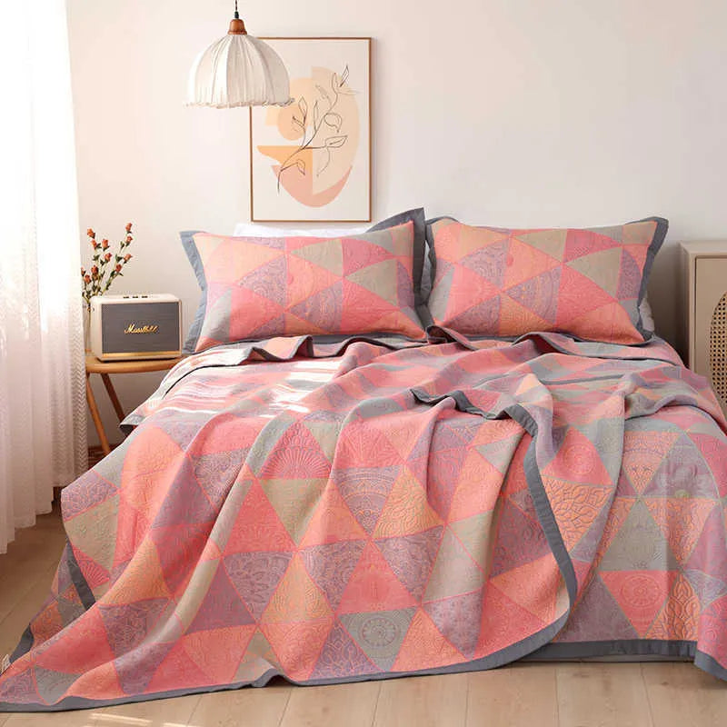 Cotton gauze floral blanket and two pillowcases set laid on a bed, showing plants and flowers pattern.