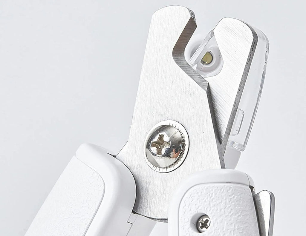 White pet nail clipper with LED light on handle and transparent anti-splash guard surrounding the blades.
