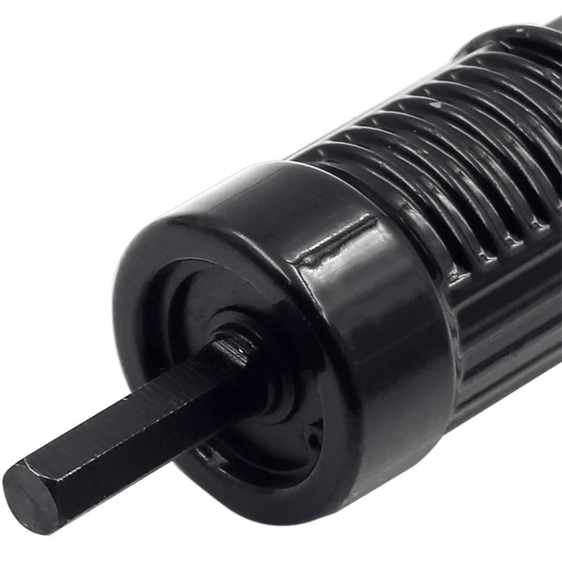 Black metal electric drill attachment rivet gun with handle, wrench, and rivet heads on a workshop bench.