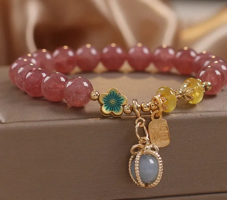 Red women's bracelet with strawberry quartz beads, alloy metal elements, and rhinestone decorative details on adjustable band