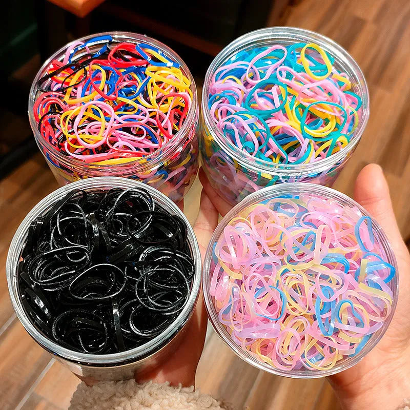 Pack of small, colourful TPU elastic hair bands for babies and toddlers in a reusable container.