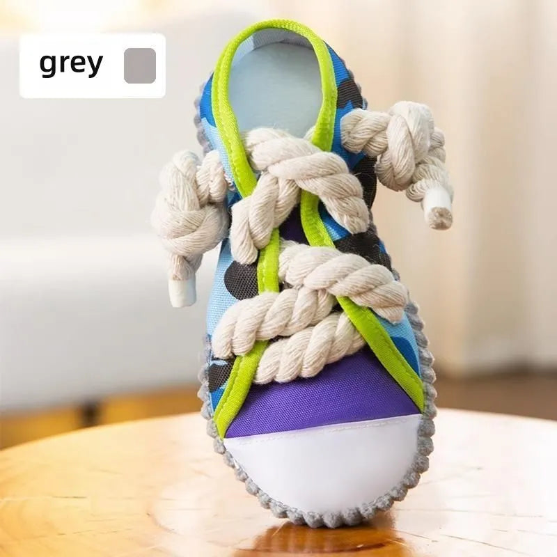 Realistic shoe-shaped dog toy in grey, purple, or yellow with laces, sole patterns, built-in squeaker and bell.