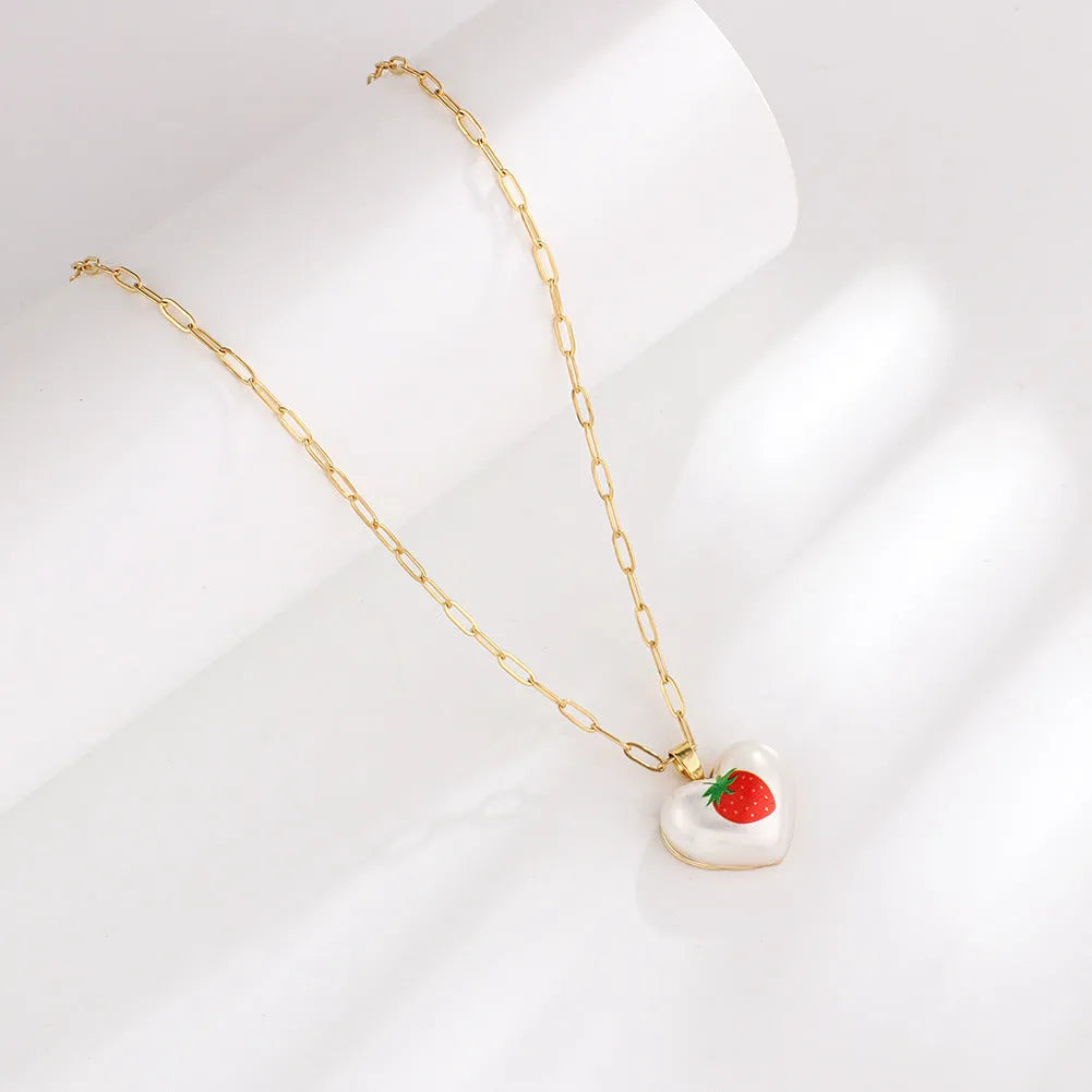 Geometric fruit pendant necklace on an adjustable chain, showing apple, cherry, pear, pineapple, and strawberry charm options.