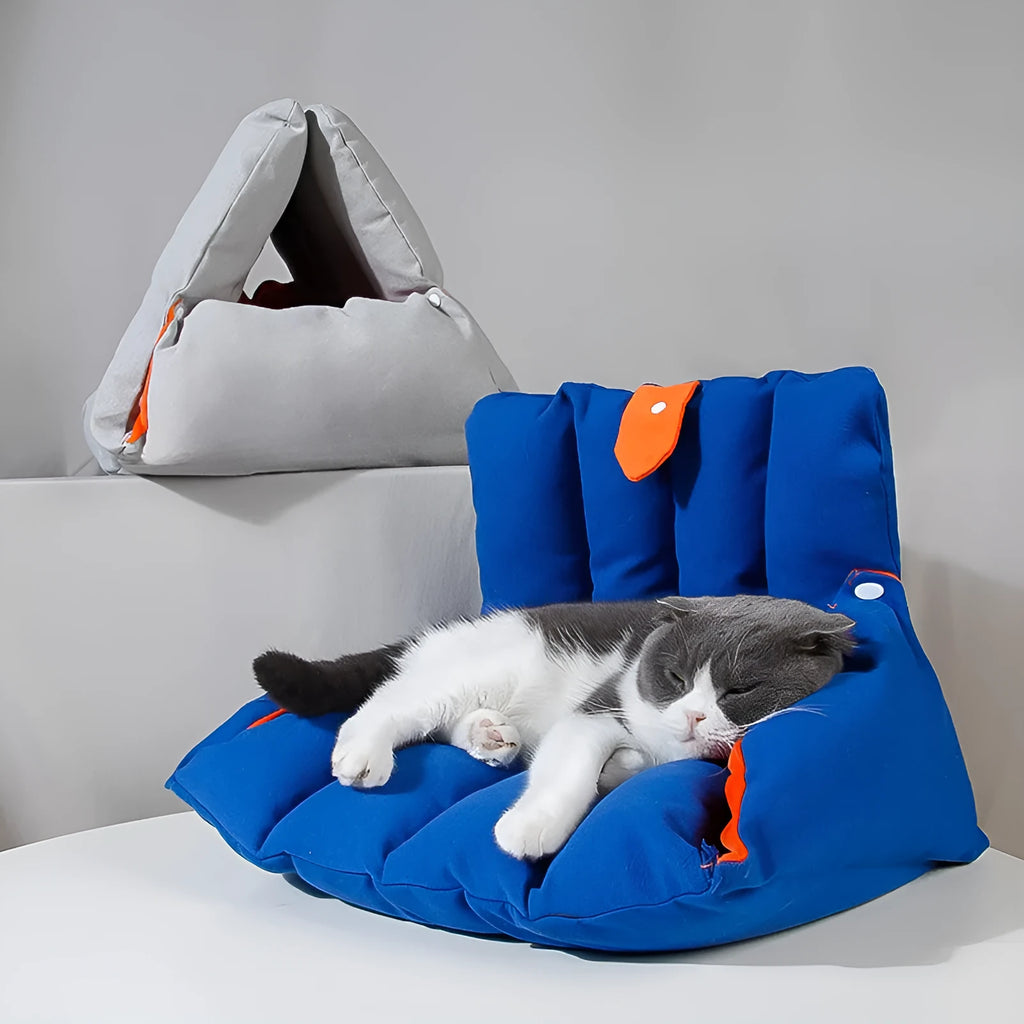 Blue triangular cat bed with drilled holes on a sofa, showing removable cotton cover.