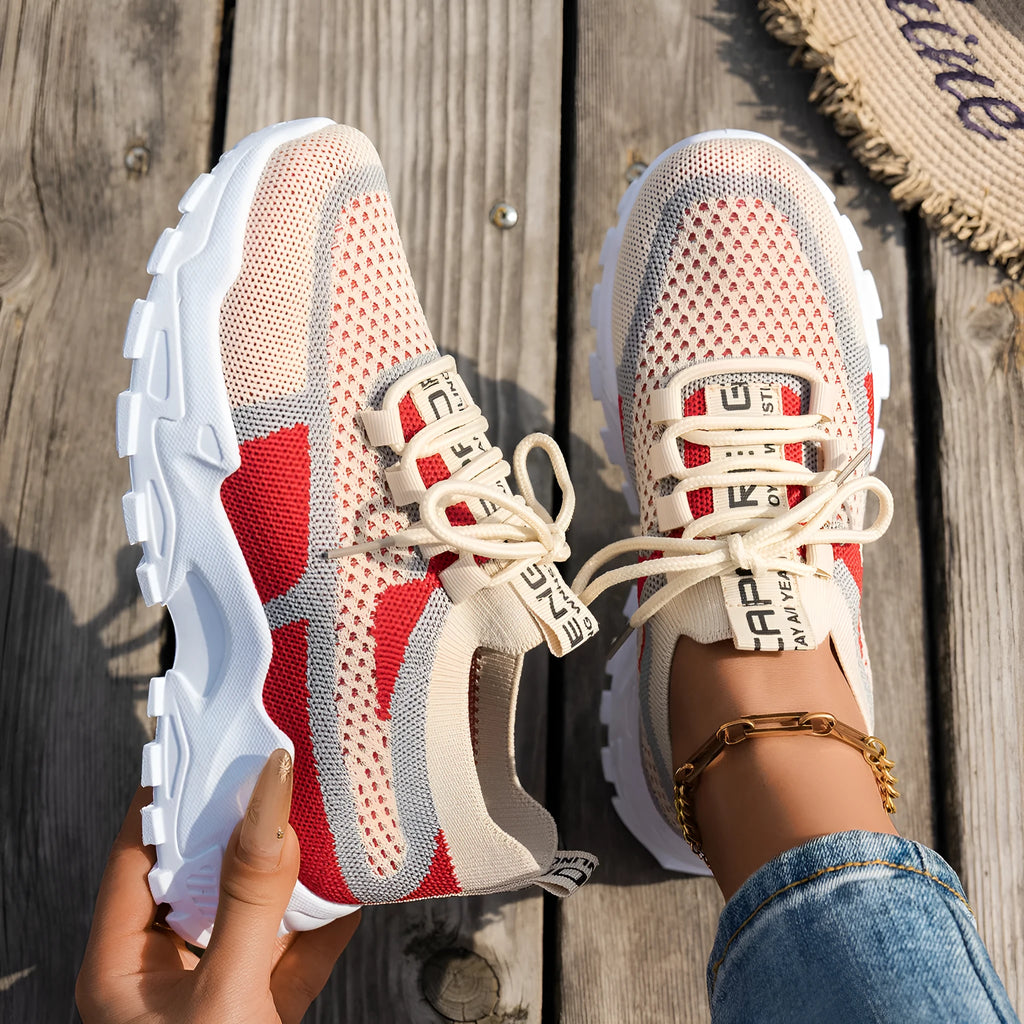 Women's Flyknit mesh sneakers in grey and white with a flat rubber sole and lace-up front.