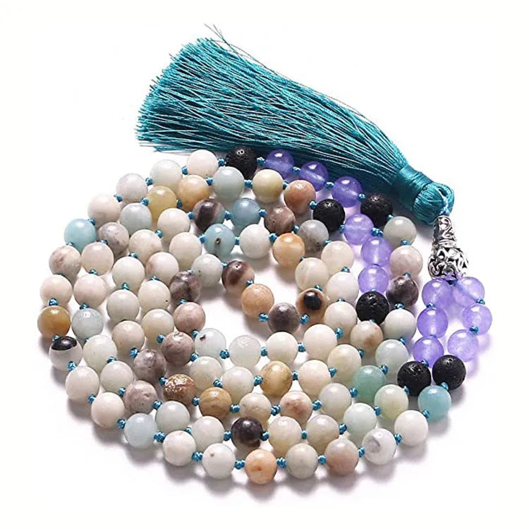 Long blue patterned agate and stone tassel necklace with geometric beads on a white background.